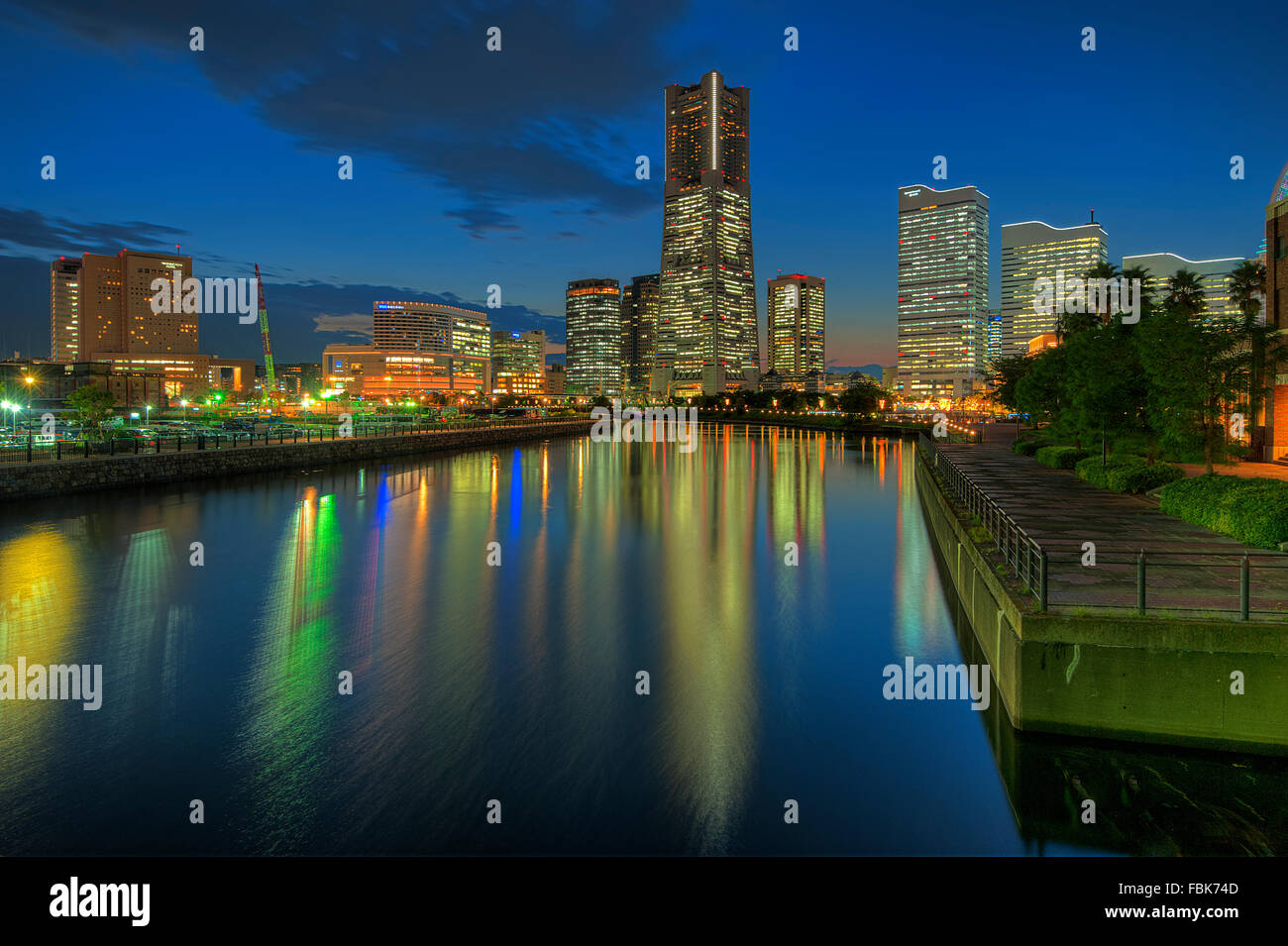 La réflexion de Yokohama Landmark Tower et les immeubles de bureaux modernes sur l'eau au cours de la fin de soirée Banque D'Images