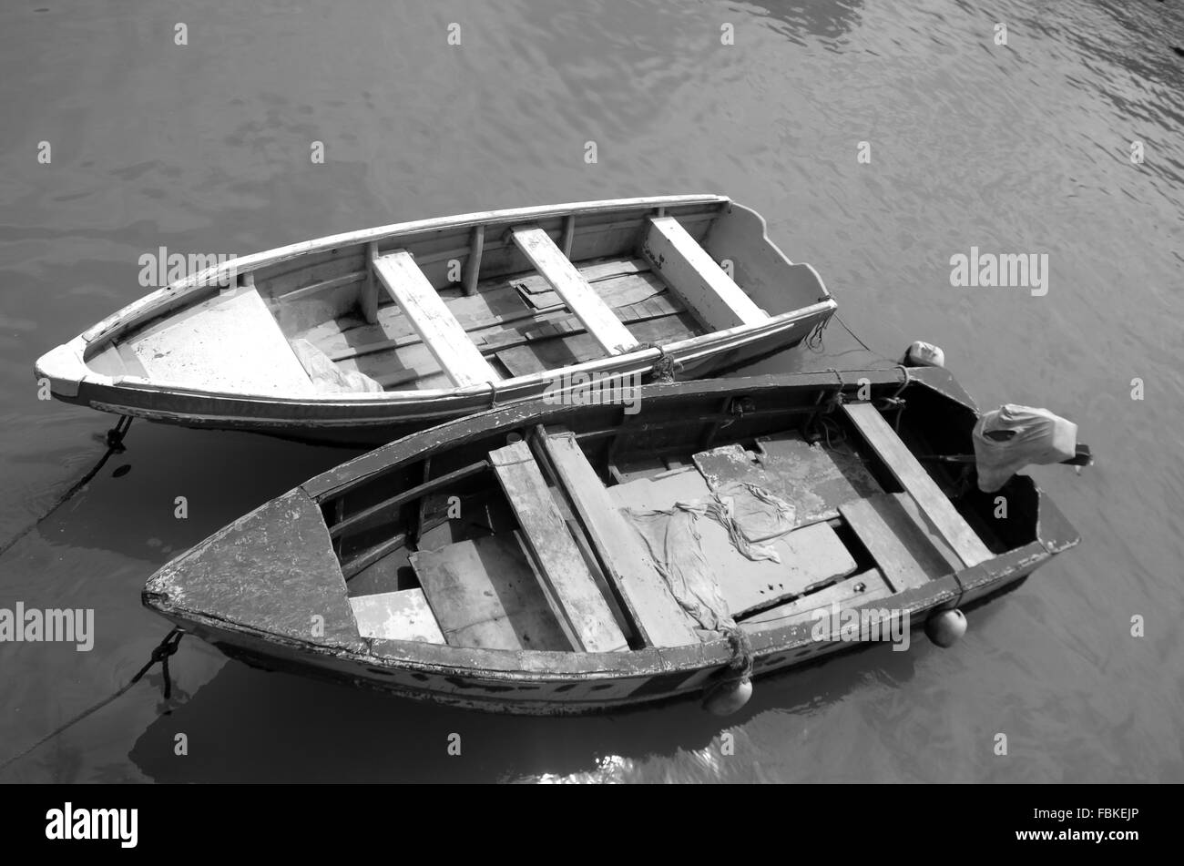 Deux petits bateaux de pêche en bois simple attachés dans la boue de l'eau coloré vert. Banque D'Images