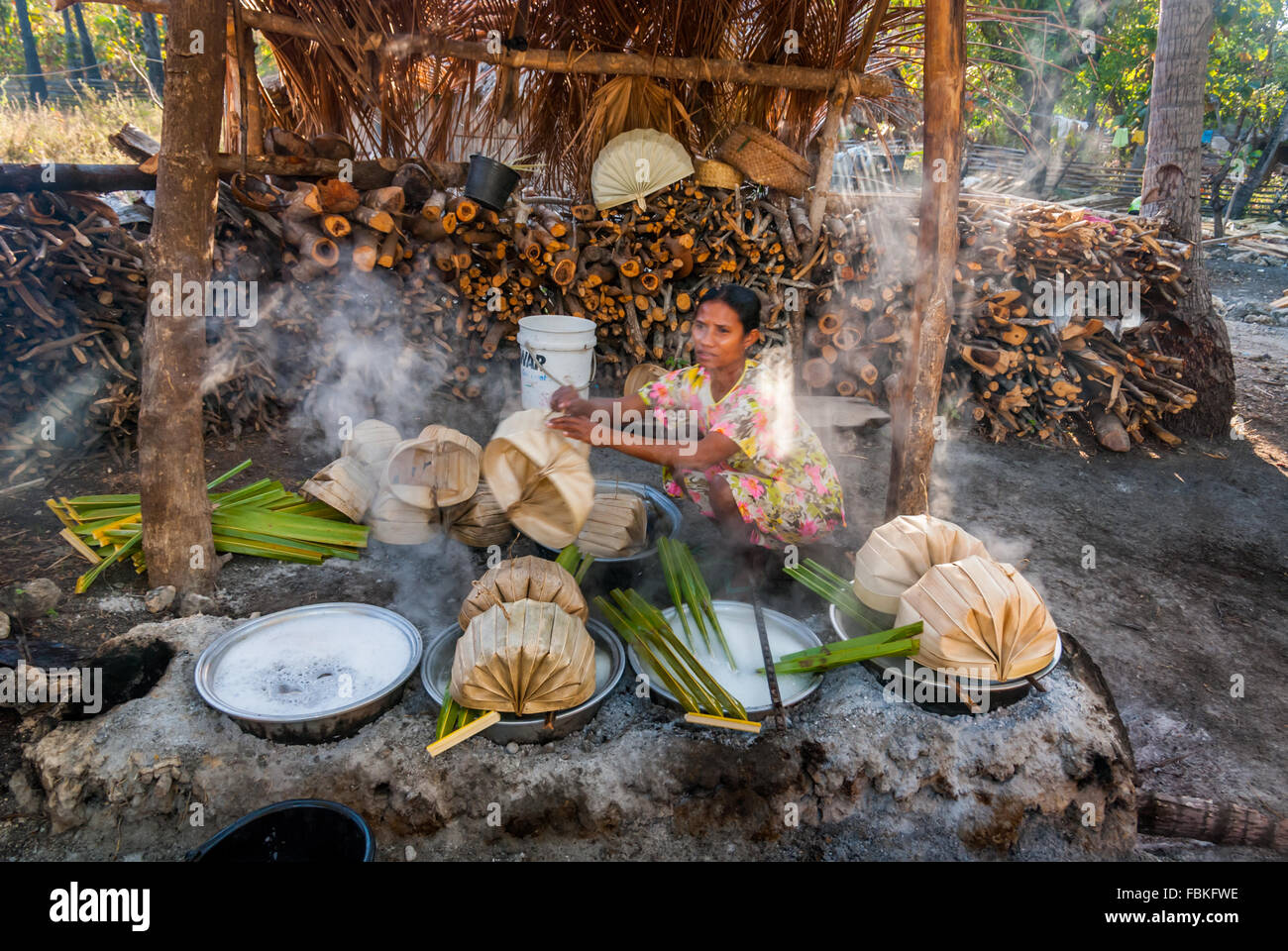 La femme bout la sève du palmier palmyra extrait de l'île de Rote dans le cadre du processus de fabrication du sucre. Banque D'Images