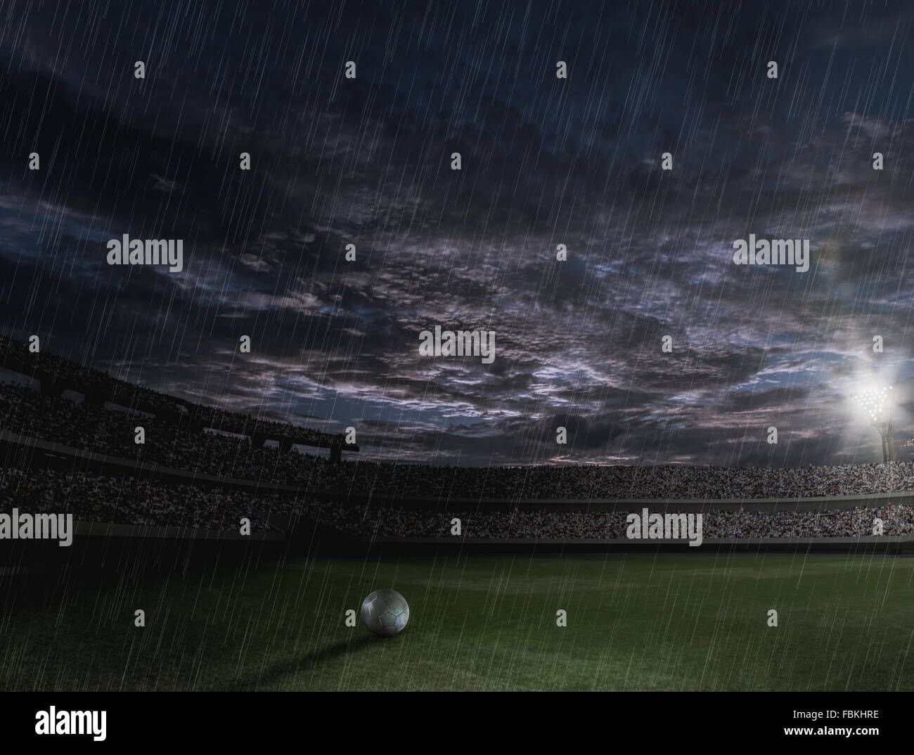 Ballon de soccer sur le terrain sur une nuit pluvieuse Banque D'Images