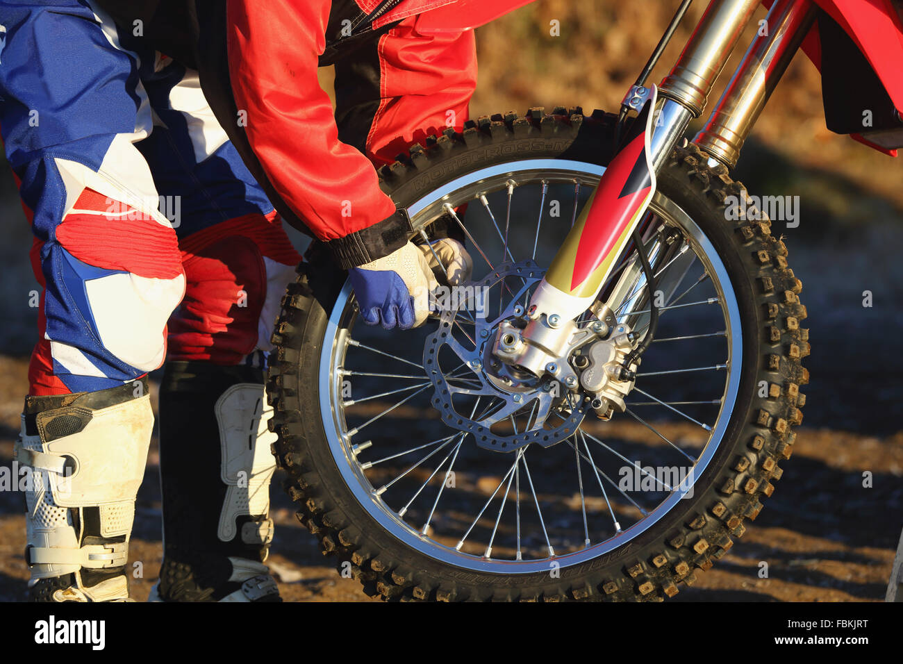 Biker Motocross travaillant sur son vélo sur un chemin de terre Banque D'Images