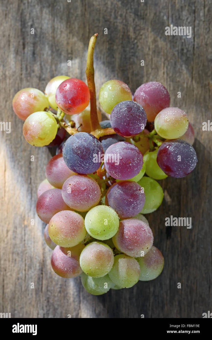 Grappe de raisins sur une surface en bois Banque D'Images