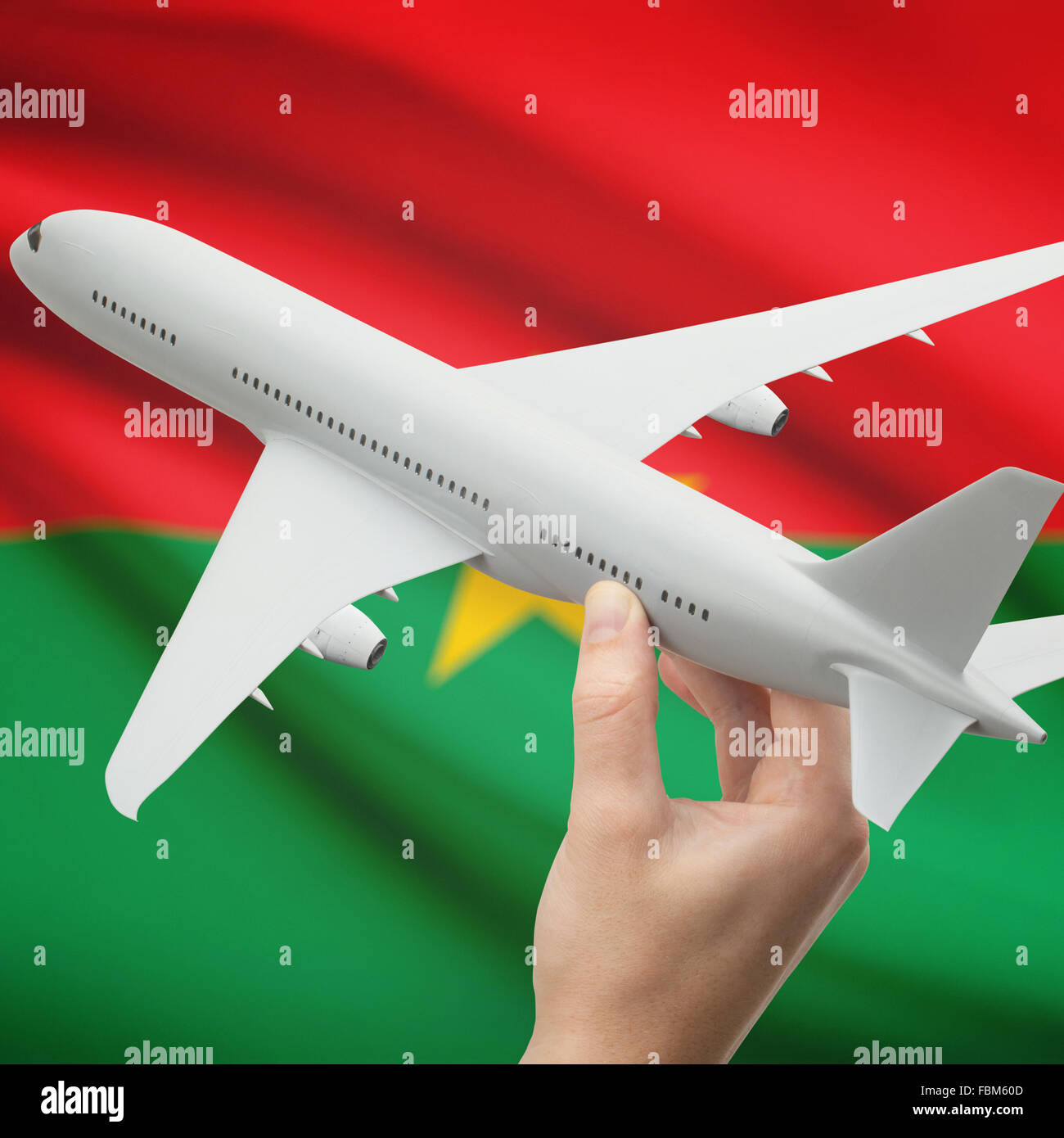 Avion en main avec drapeau national sur fond de série - Burkina Faso Banque D'Images