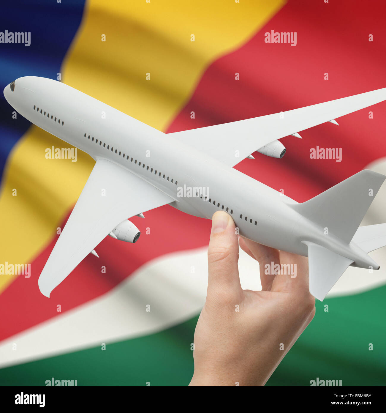 Avion en main avec drapeau national sur fond de série - Seychelles Banque D'Images