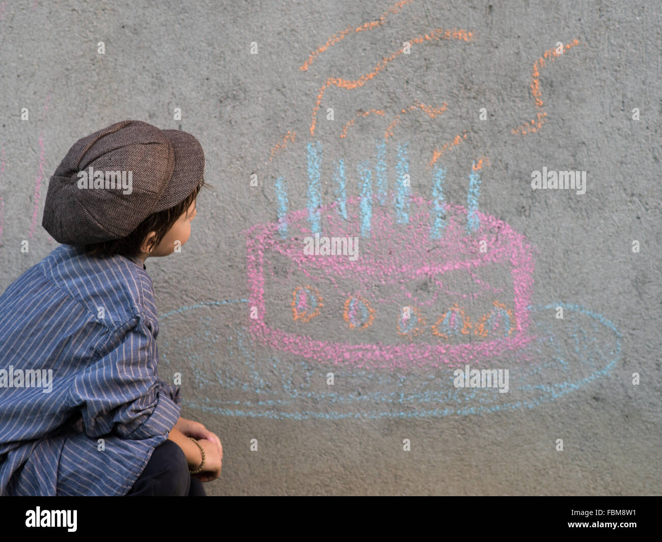 Dessin garçon gâteau d'anniversaire sur le mur avec de la craie Banque D'Images