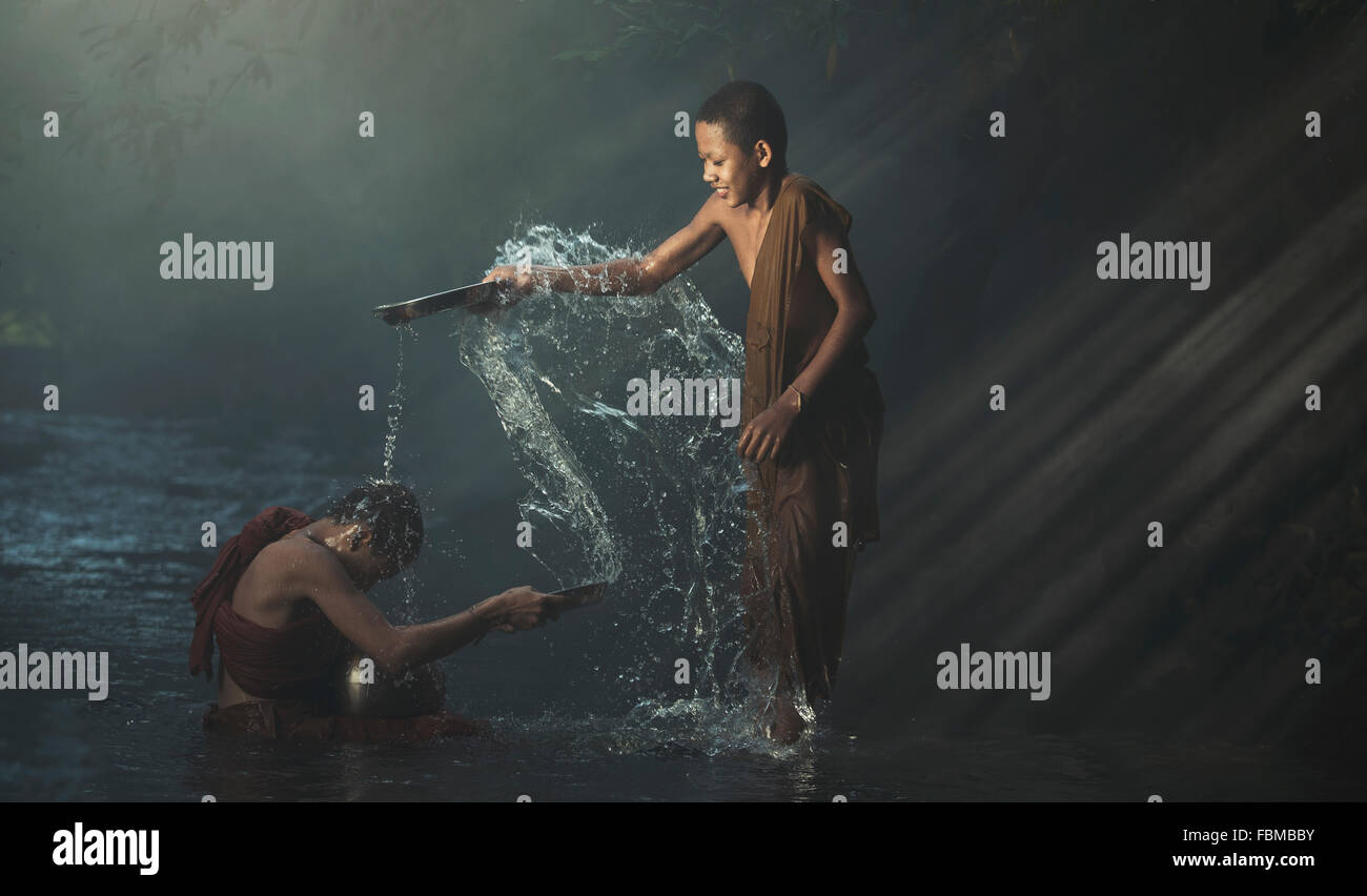 Les moines novices jouant avec de l'eau dans un ruisseau, le Myanmar Banque D'Images