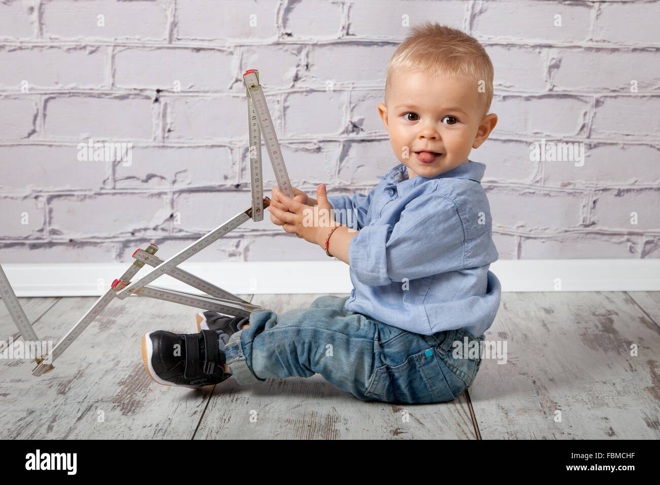 Enfant jouant avec un mètre Banque D'Images