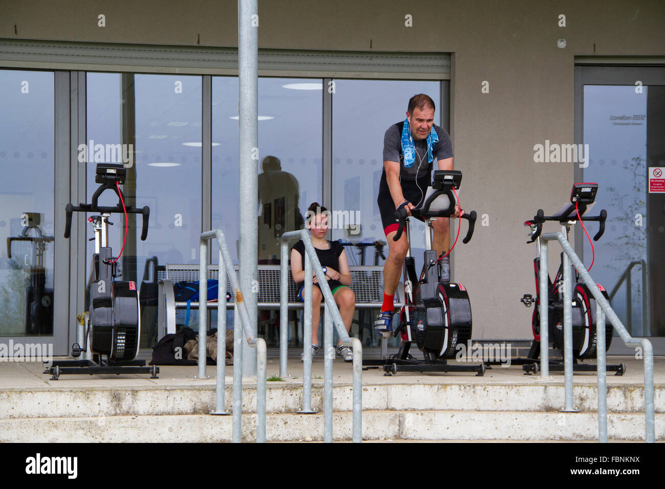 Homme d'âge moyen sur un vélo d'exercice au centre de cyclisme Redbridge Banque D'Images