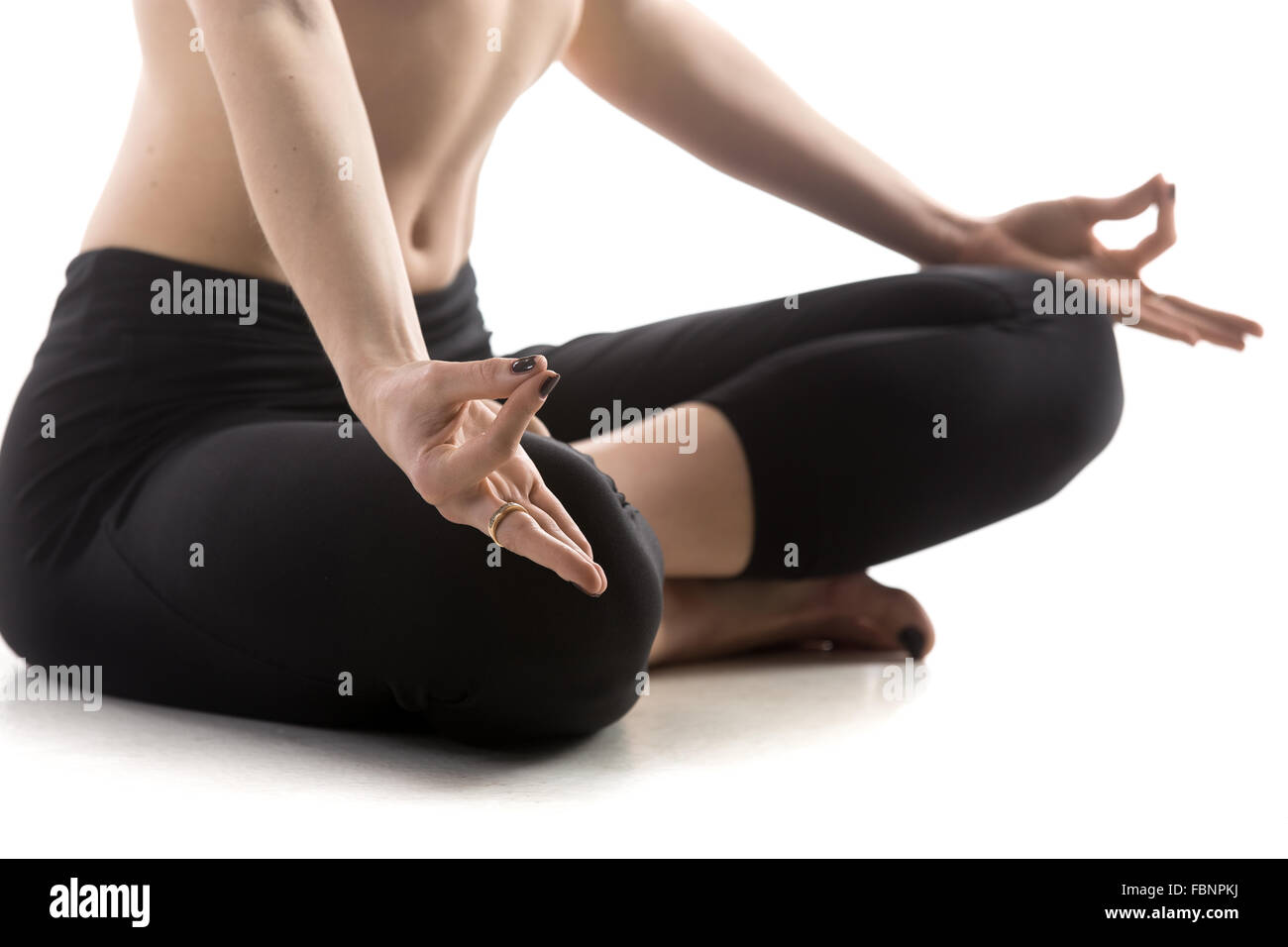 Belle jeune femme fit sport sportswear pantalon noir dans l'élaboration, assis en posture Sukhasana, facile, sur la méditation Banque D'Images