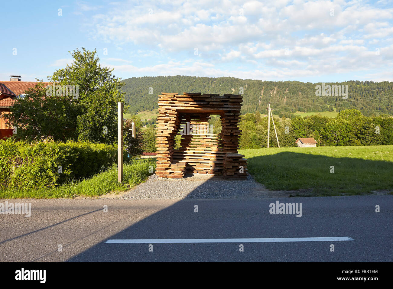 Sur la route avec abri bus dans la lumière du matin. Arrêt de bus à Unterkrumbach Nord par Studio Ensamble, Unterkrumbach, Autriche. Architecte : Banque D'Images