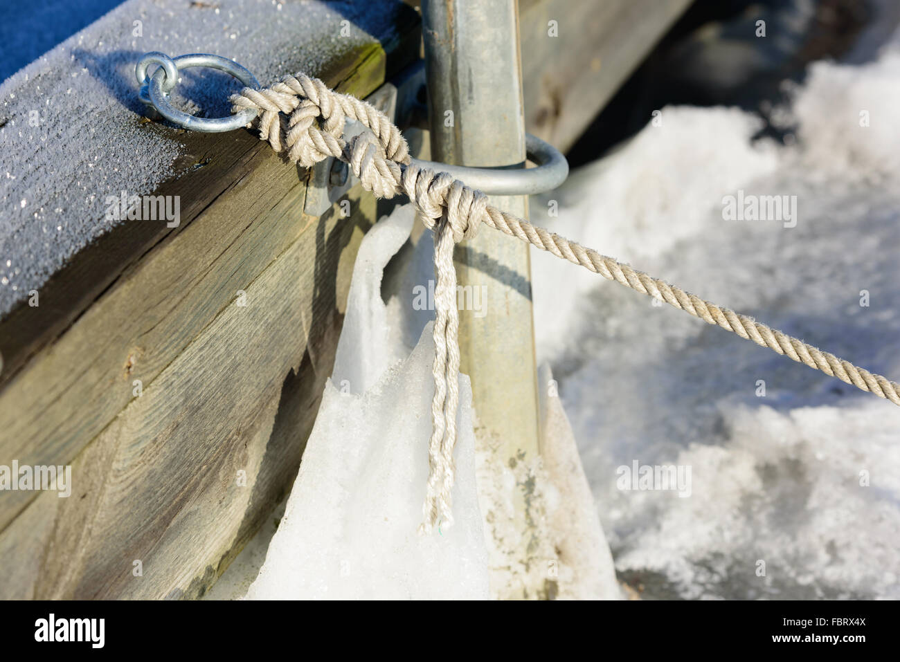 Close up of white corde attachée à un quai en hiver. Banque D'Images