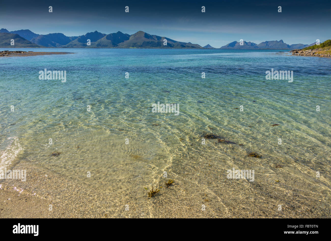 L'eau de mer peu profonde clair avec île lointaine, Norvège Banque D'Images