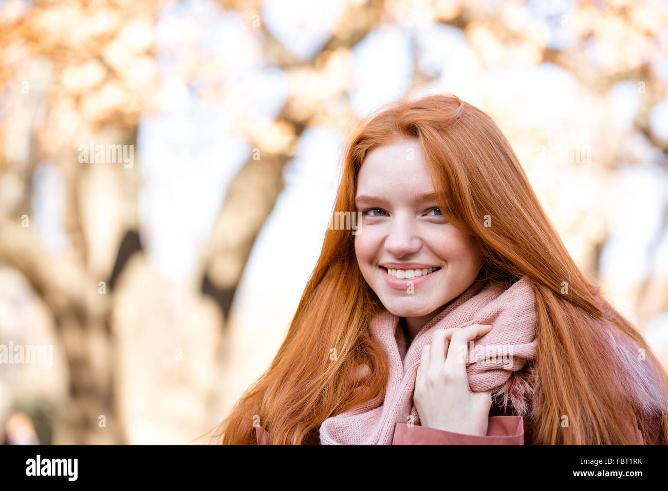 Portrait of a smiling redhead woman looking at camera outdoors Banque D'Images