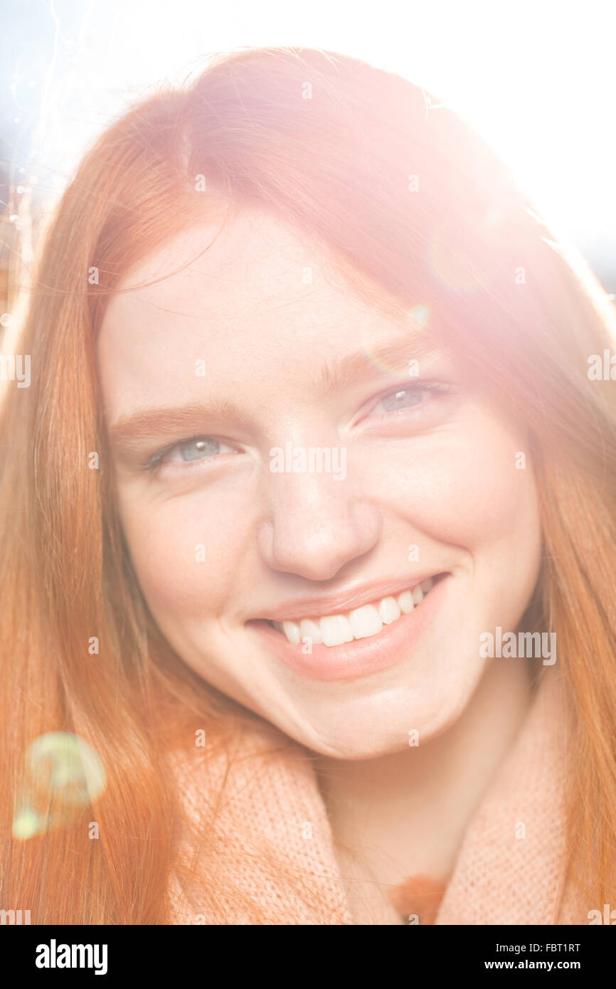 Closeup portrait of a smiling redhead woman looking at acamera Banque D'Images