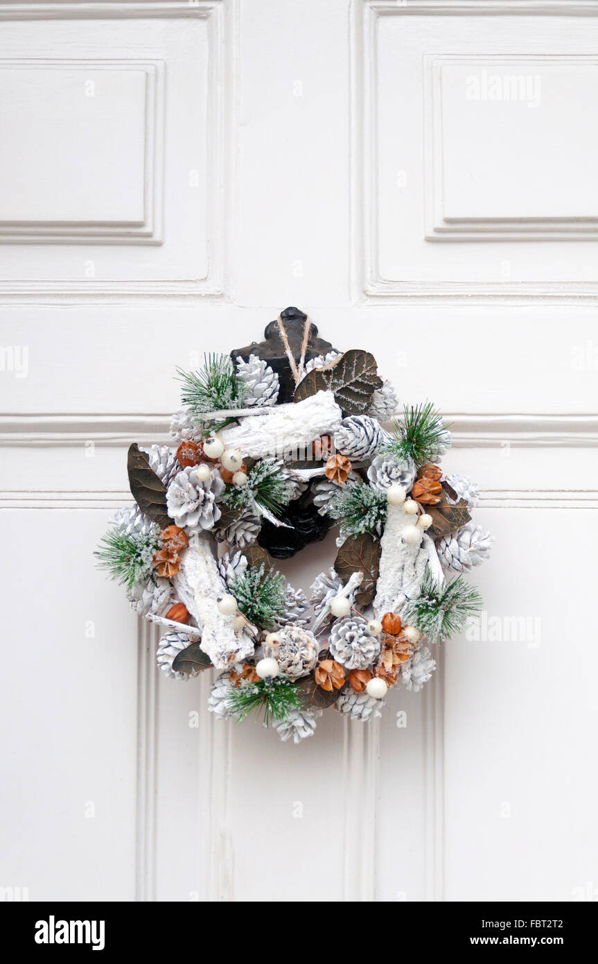 Couronne de Noël blanc sur la pendaison de porte avant Banque D'Images