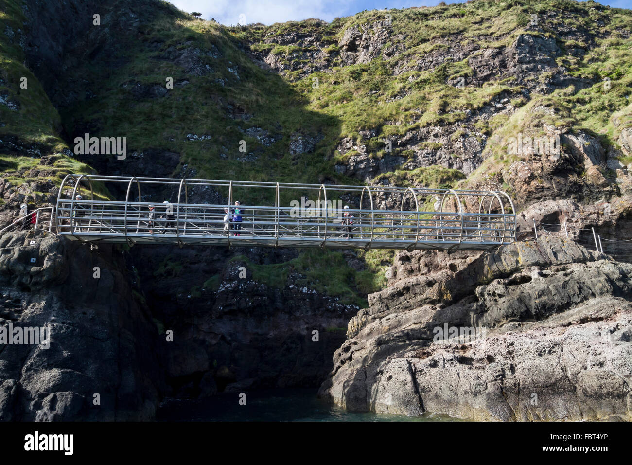 Promenade côtière en Irlande du Nord. Les promeneurs traversant pont métallique sur la falaise à pied Chemin Gobbins dans le comté d'Antrim, en Irlande du Nord. Banque D'Images