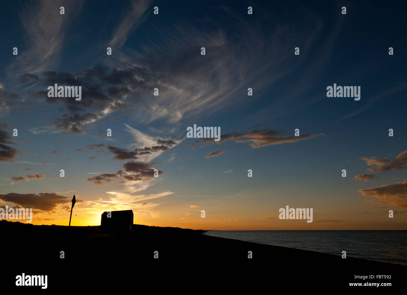 Silhouette d'une remise sur une plage de Norfolk, England, UK , au coucher du soleil Banque D'Images