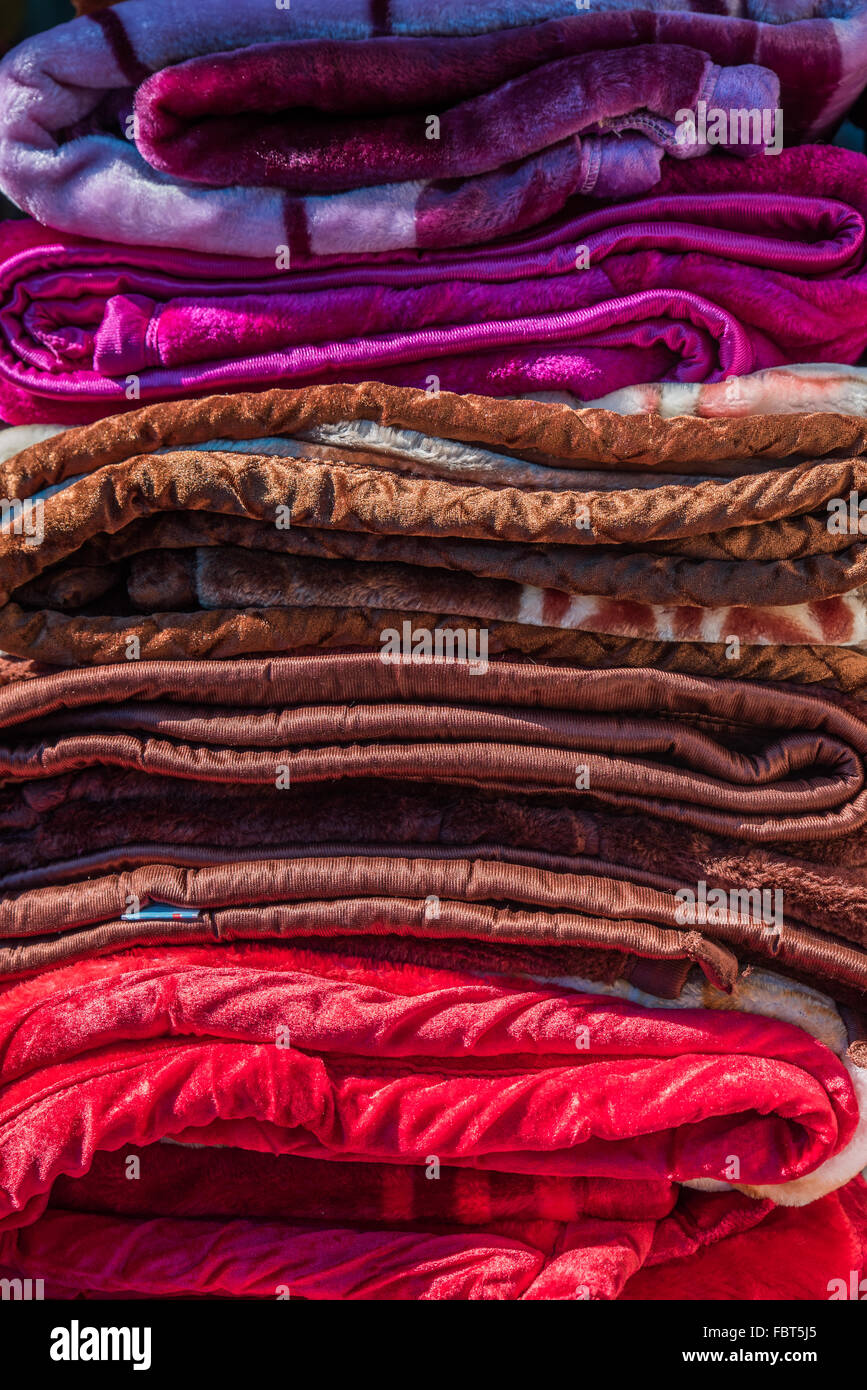 Marché indien. Une pile de couvertures vibrantes à vendre au marché du samedi Balipara, près de Tezpur, Assam, INDE. Banque D'Images