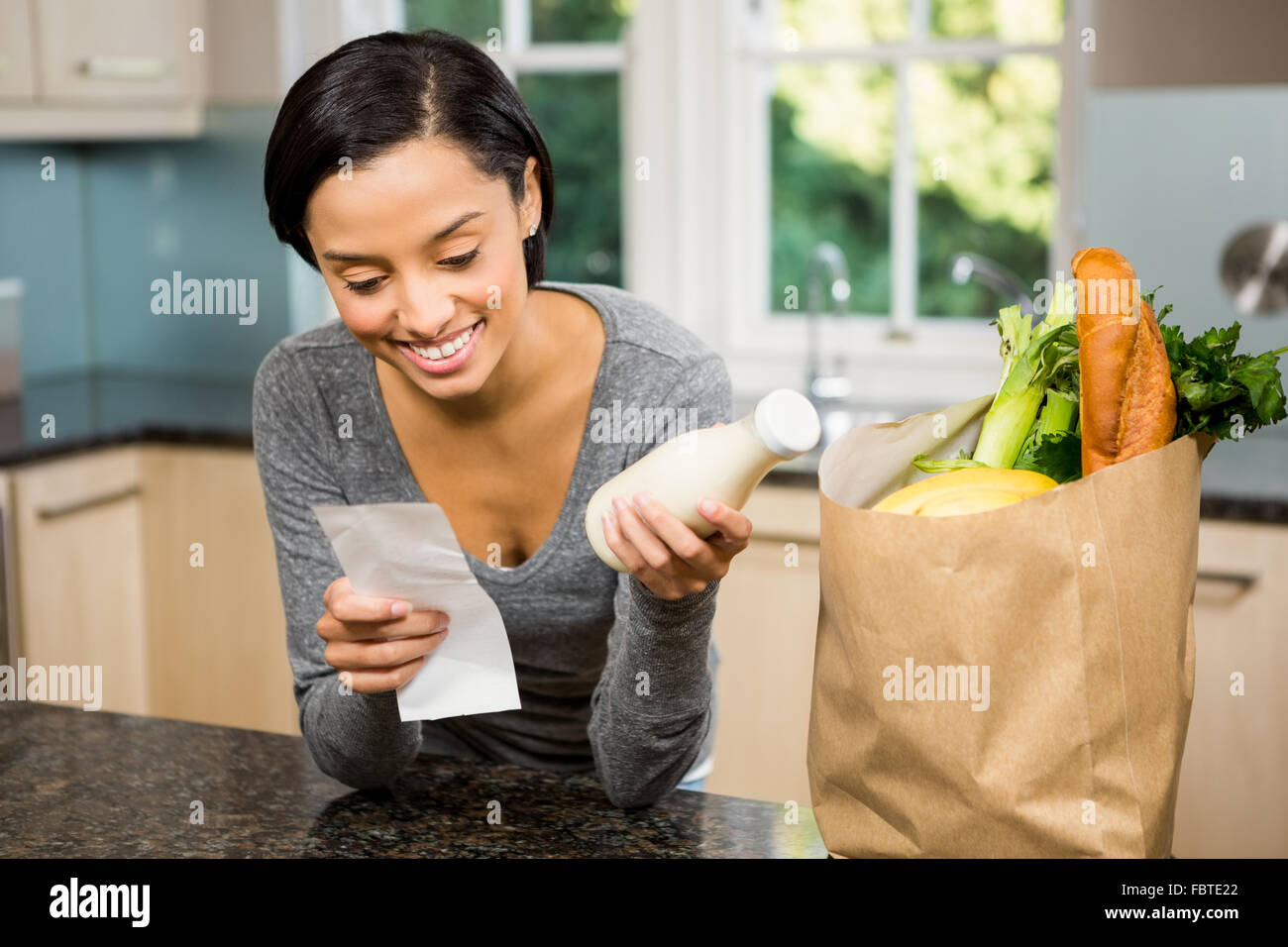 Smiling brunette holding réception et le lait Banque D'Images