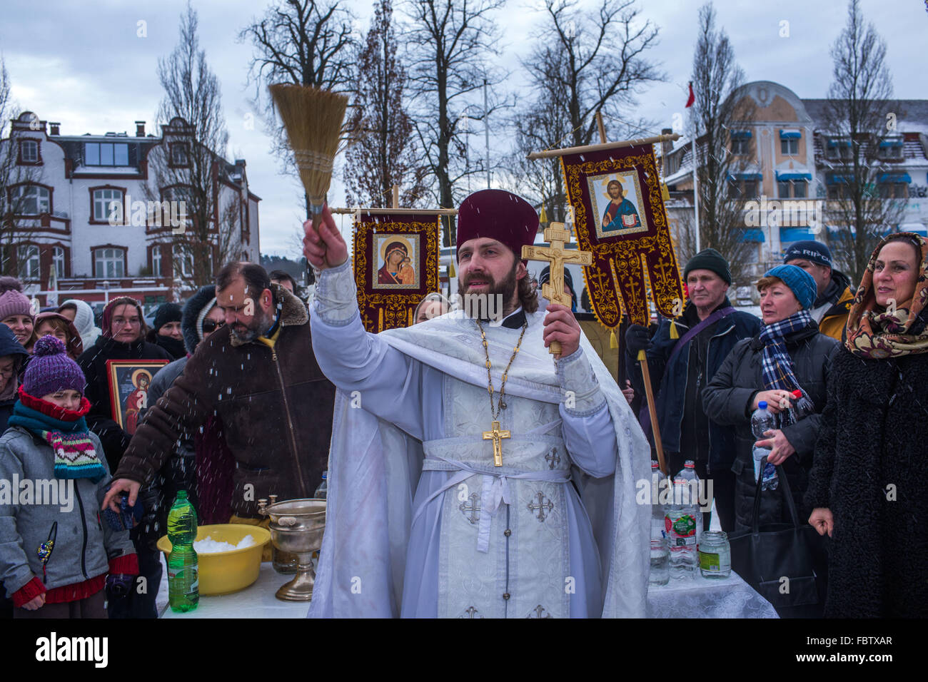 Schwerin, Allemagne. 19 Jan, 2016. Prêtre Orthodoxe Russe Idavain Dionisi bénit les membres de sa communauté, sur les rives du lac de Schwerin, au cours de la quatrième bénédiction Orthodoxe Russe des eaux, à Schwerin, Allemagne, 19 janvier 2016. Selon le calendrier grégorien, le 19 janvier est le jour du baptême de Jésus. PHOTO : JENS BUETTNER/DPA/Alamy Live News Banque D'Images
