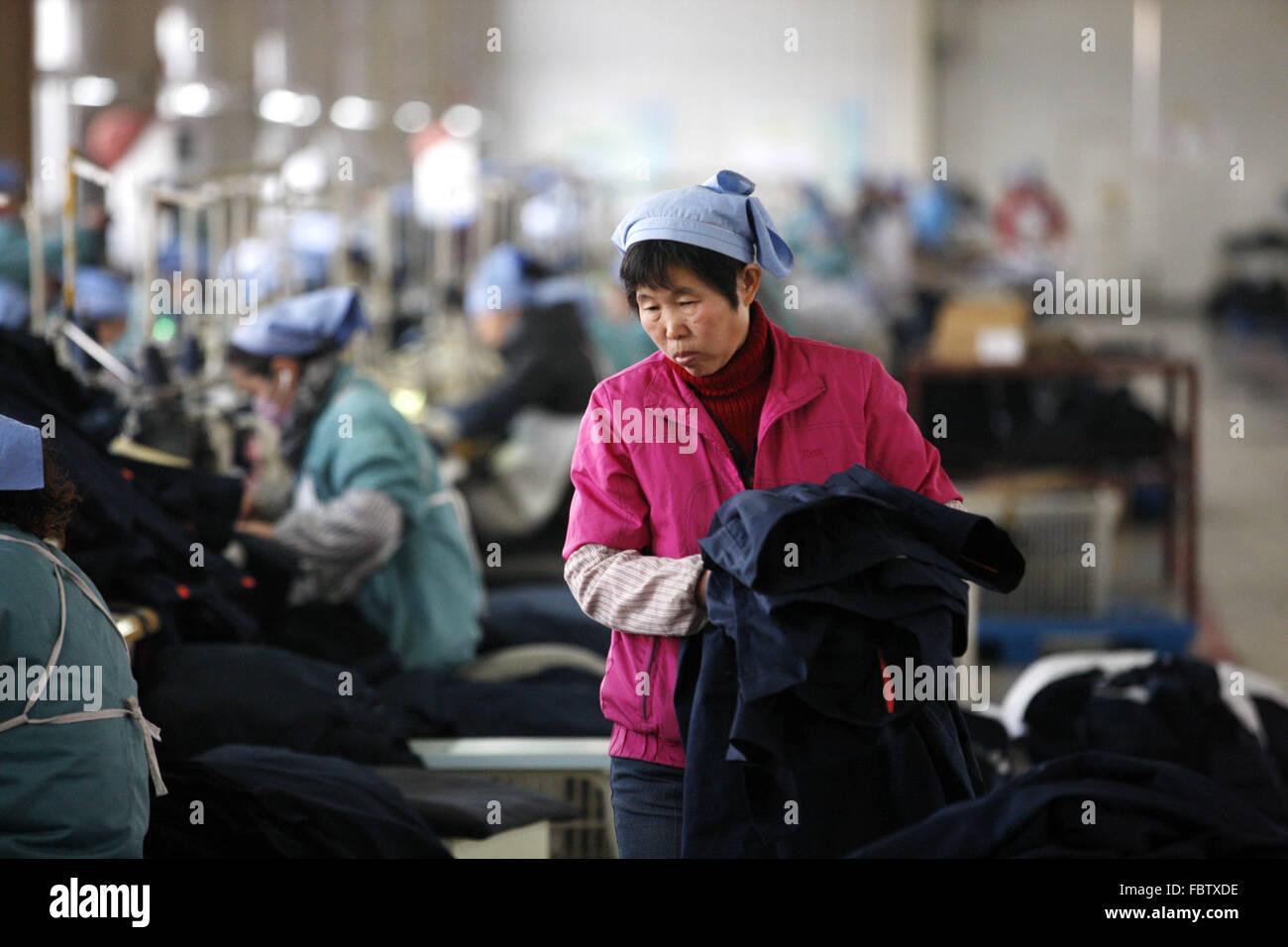 Travail des femmes travaille dans une usine de tissu dans la ville de Huaibei, Anhui province de Chine orientale, le 19 Jan 2016. L'économie de la Chine a progressé à son rythme plus lent dans un quart de siècle en 2015, les données publiées le mardi a montré. L'ensemble de l'année croissance de 6,9 % n'en est qu'à aux attentes des autorités de 7  % mais, par contraste, la croissance en 2014 s'élevait à 7,3  %. Banque D'Images