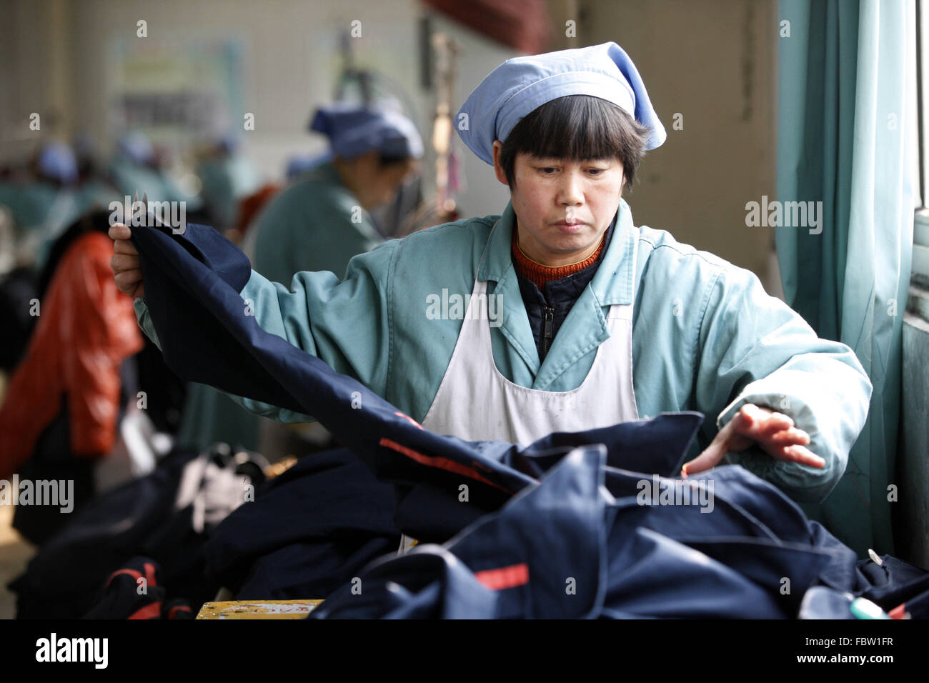 Travail des femmes travaille dans une usine de tissu dans la ville de Huaibei, Anhui province de Chine orientale, le 19 Jan 2016. L'économie de la Chine a progressé à son rythme plus lent dans un quart de siècle en 2015, les données publiées le mardi a montré. L'ensemble de l'année croissance de 6,9 % n'en est qu'à aux attentes des autorités de 7  % mais, par contraste, la croissance en 2014 s'élevait à 7,3  %. Banque D'Images