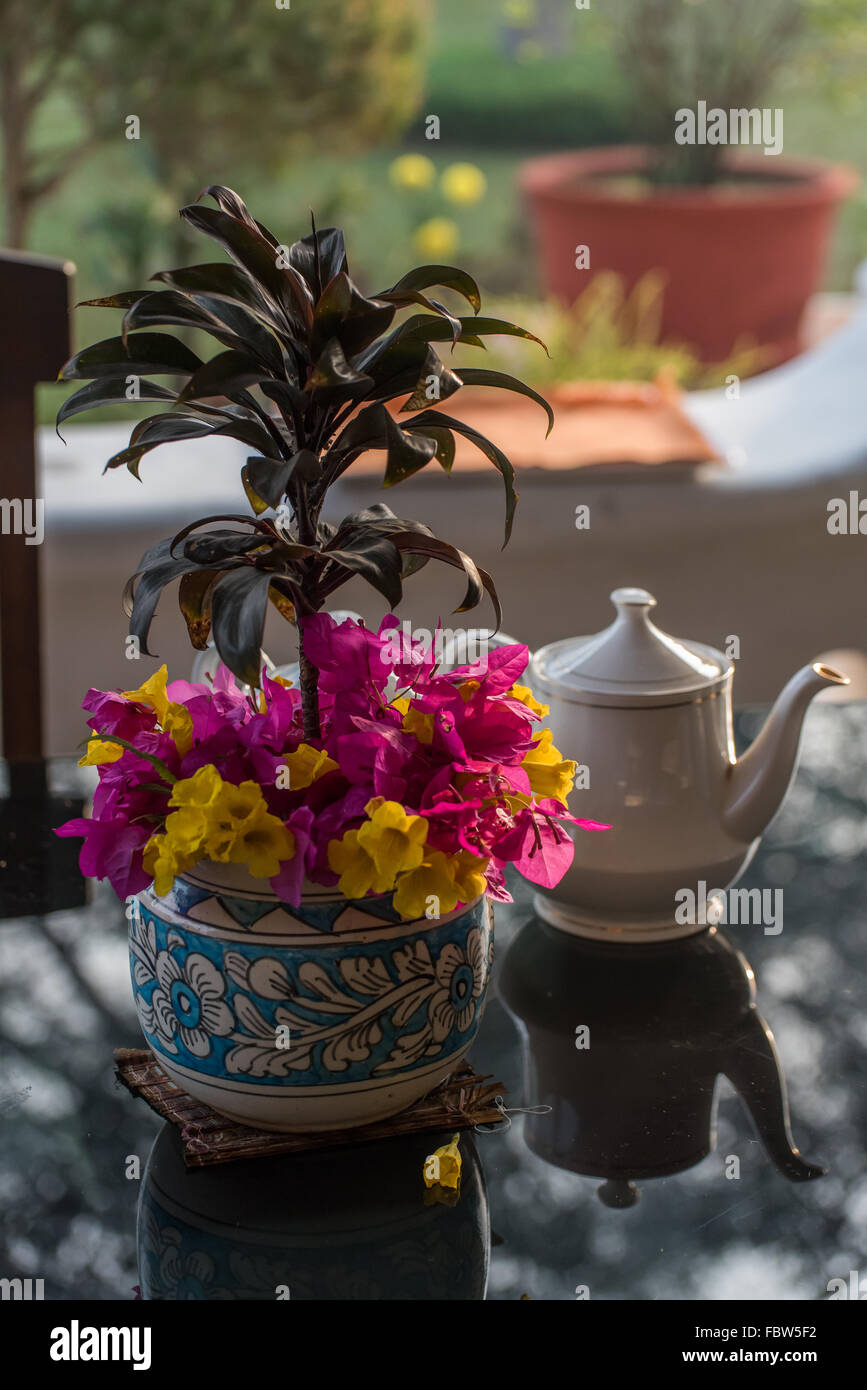 Still Life de théière avec fleurs roses et jaunes et de réflexion. Heure du thé à la Colonial Banyan Grove plantation de thé, de l'Assam Banque D'Images