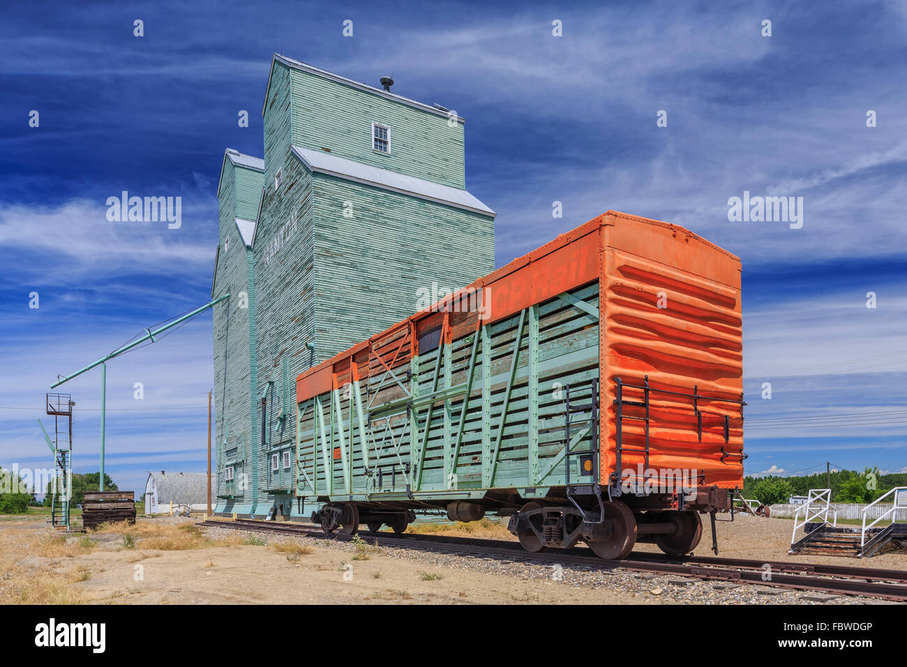 Une boîte de fer voiture ou wagon à bestiaux, et d'élévateurs à grains, Nanton (Alberta), Canada. Banque D'Images