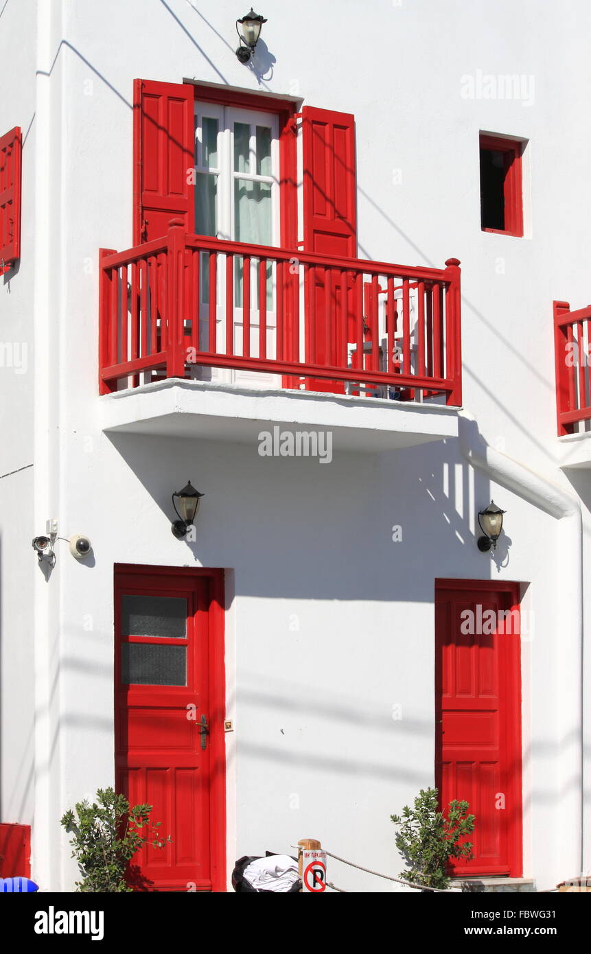 Belle maison blanche avec portes et fenêtres de couleur rouge dans l'île de Mykonos, Grèce Banque D'Images