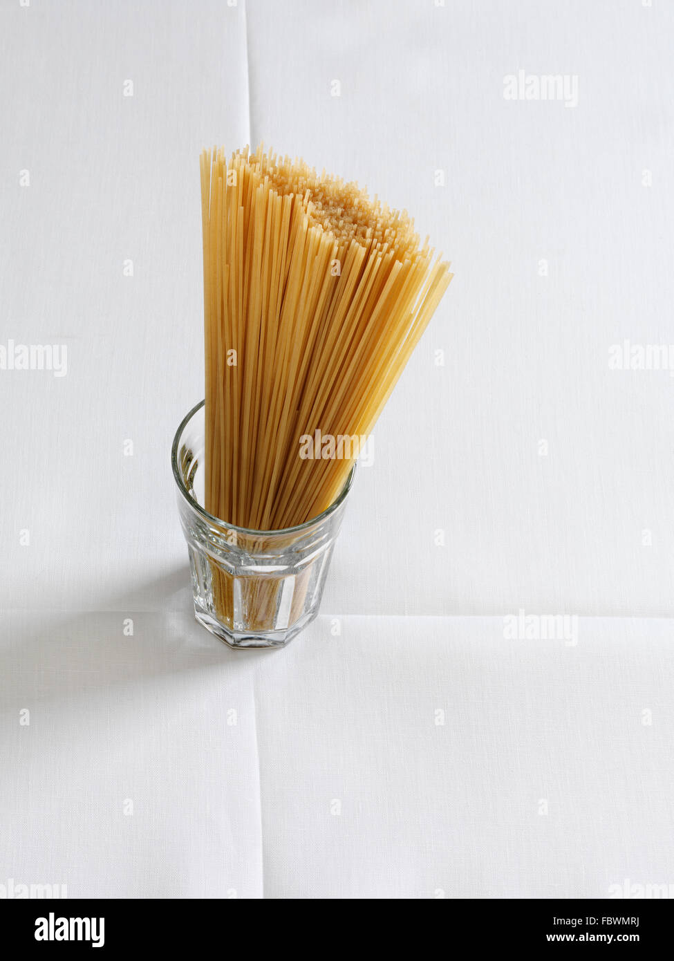 Verre à spaghetti sur une nappe de lin blanc avec plis pliage de Banque D'Images