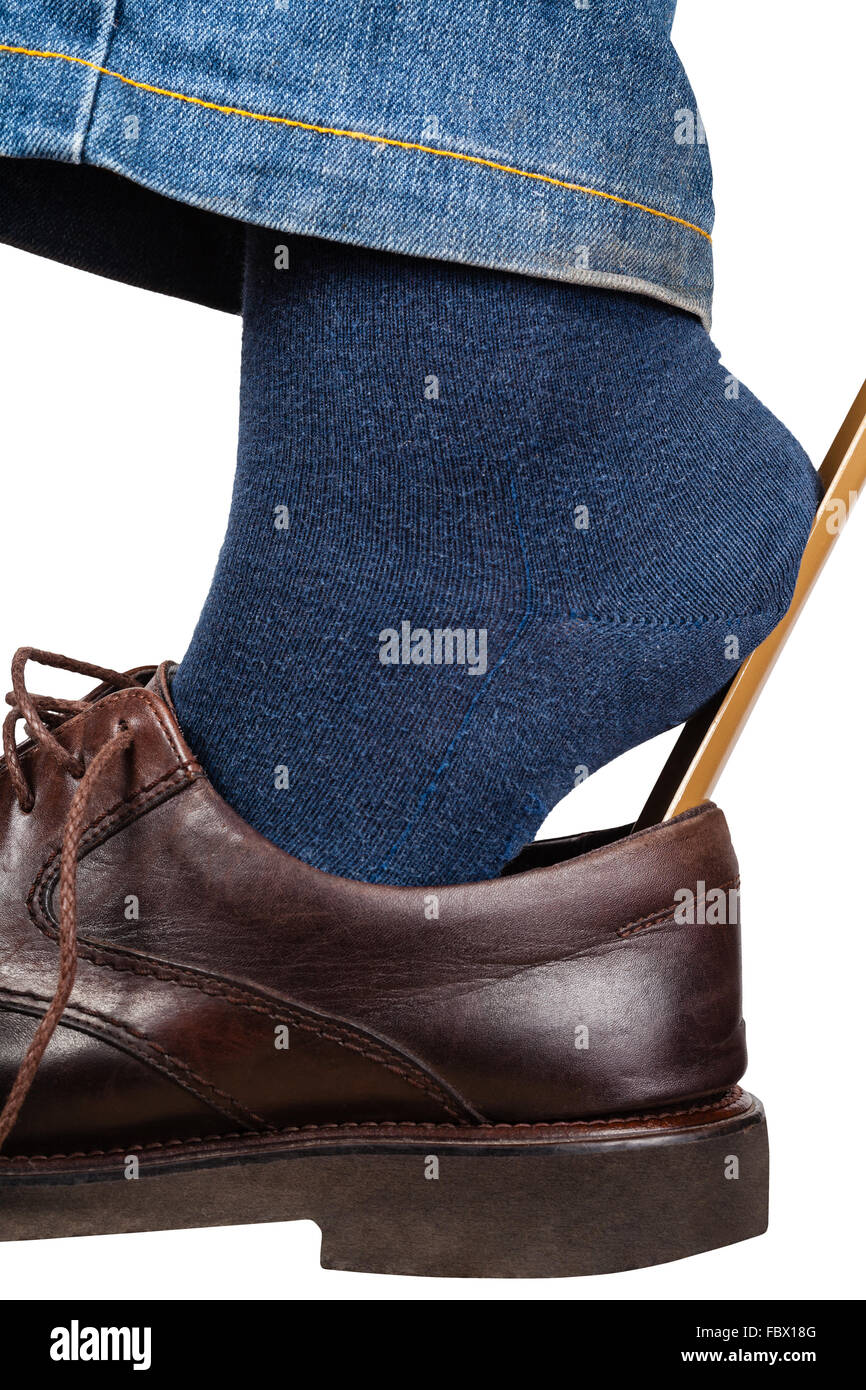 L'homme enfile chaussures brunes à l'aide d'un chausse isolé sur fond blanc  Photo Stock - Alamy