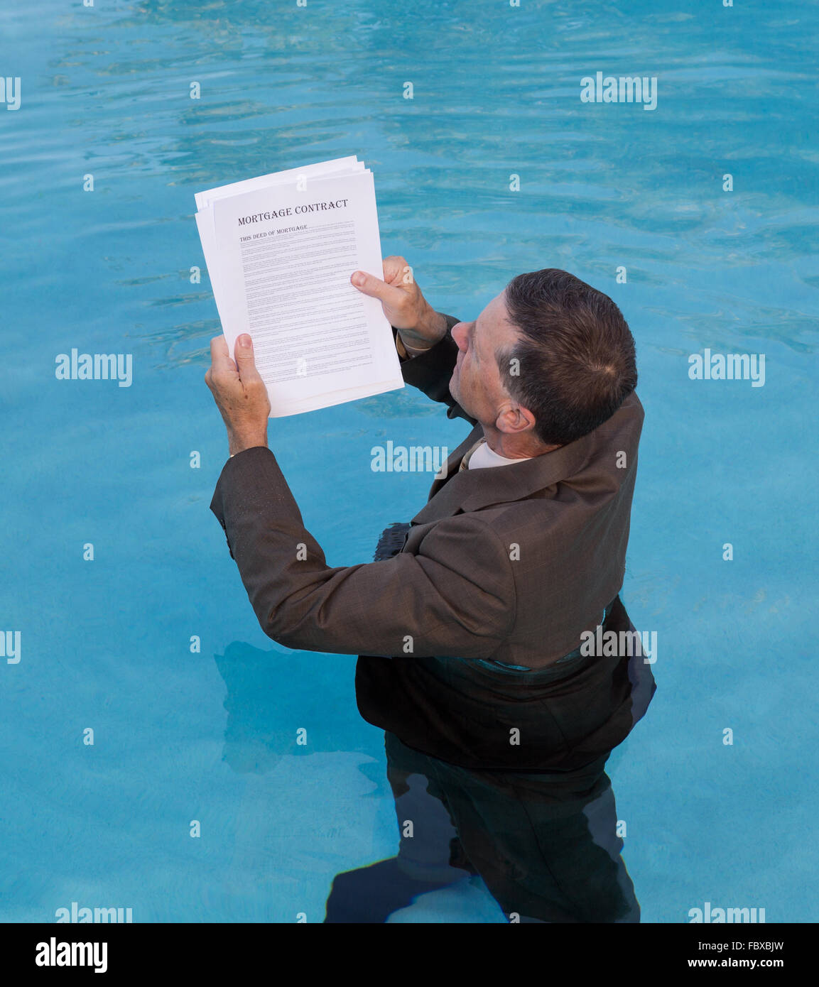 Senior man holding document prêt hypothécaire dans l'eau Banque D'Images