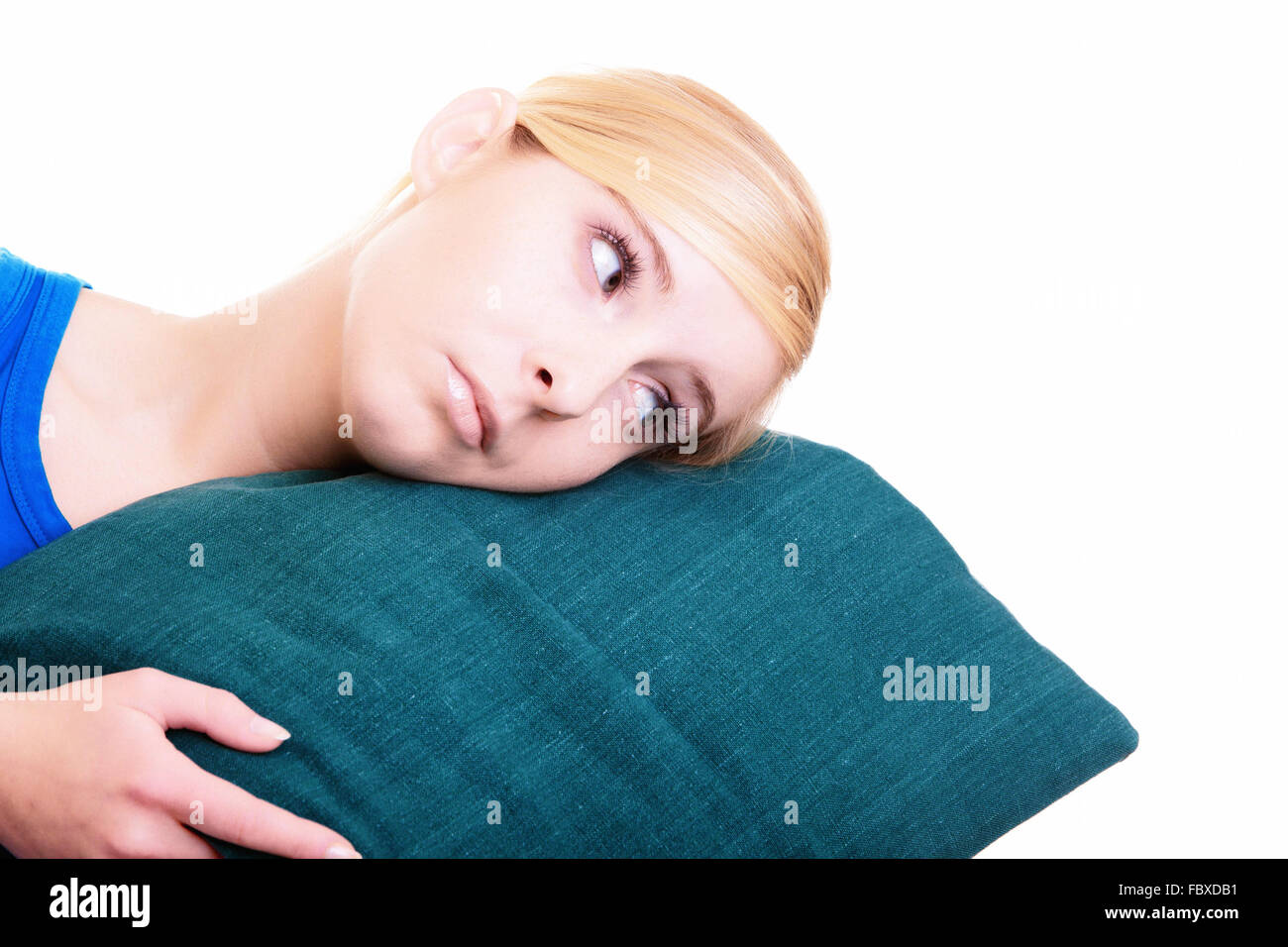 Sleepy fille blonde avec oreiller vert isolated over white Banque D'Images