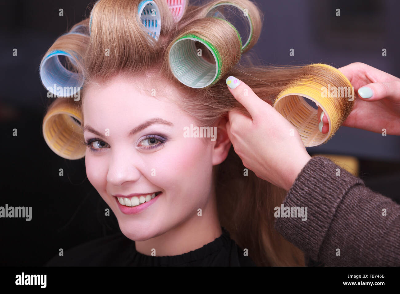 Fille blonde les bigoudis rouleaux en coiffure dans salon de coiffure Photo  Stock - Alamy