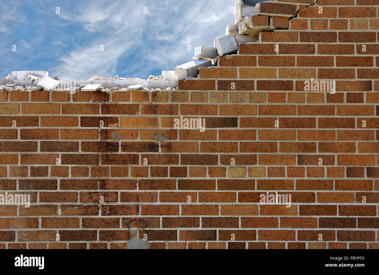Mur de briques en ruine avec filandreux nuages dans le ciel bleu. Banque D'Images Mur de briques en ruine avec filandreux nuages dans le ciel bleu. Banque D'Images