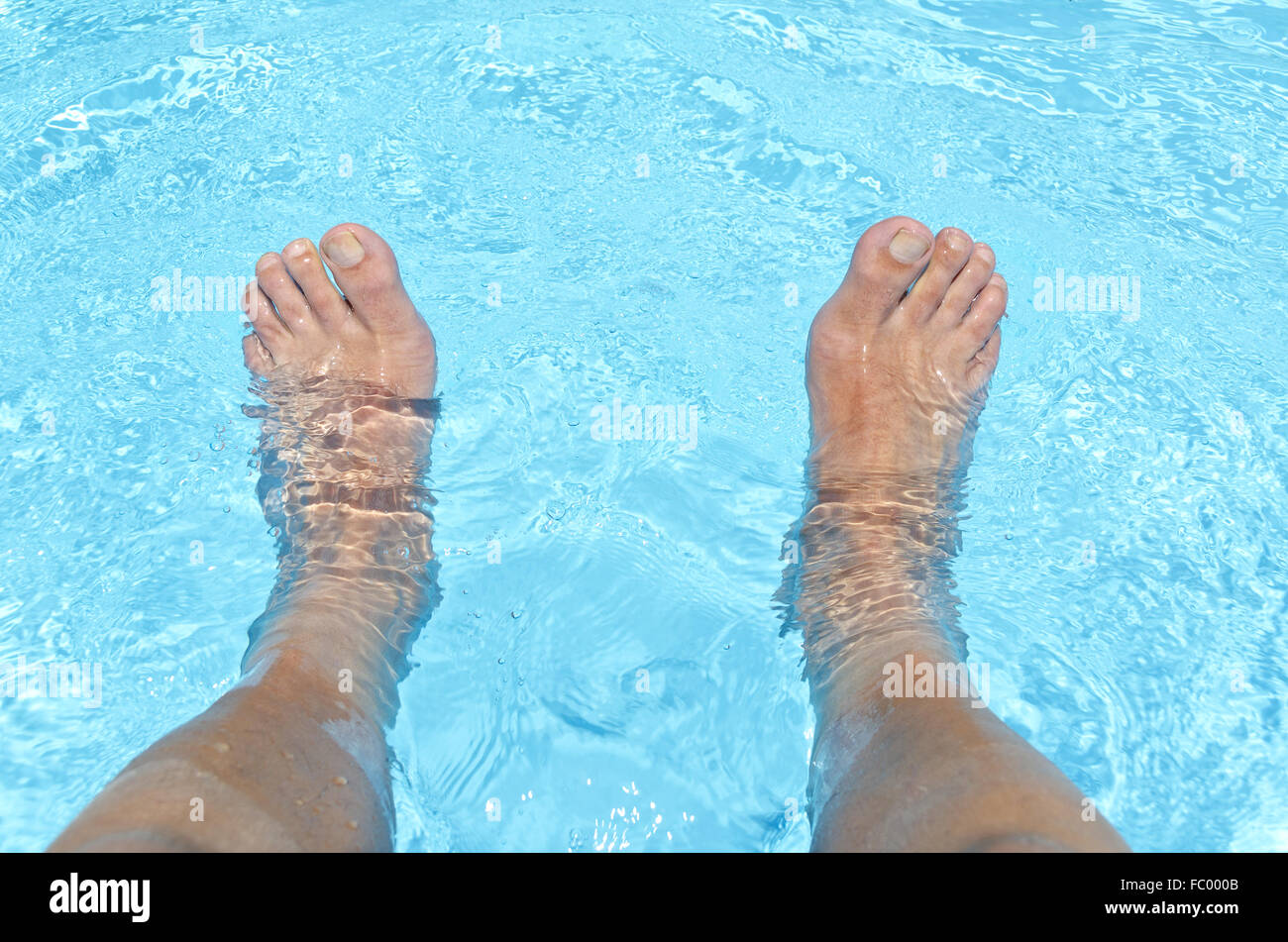 Pieds d'hommes nus dans l'eau Banque D'Images