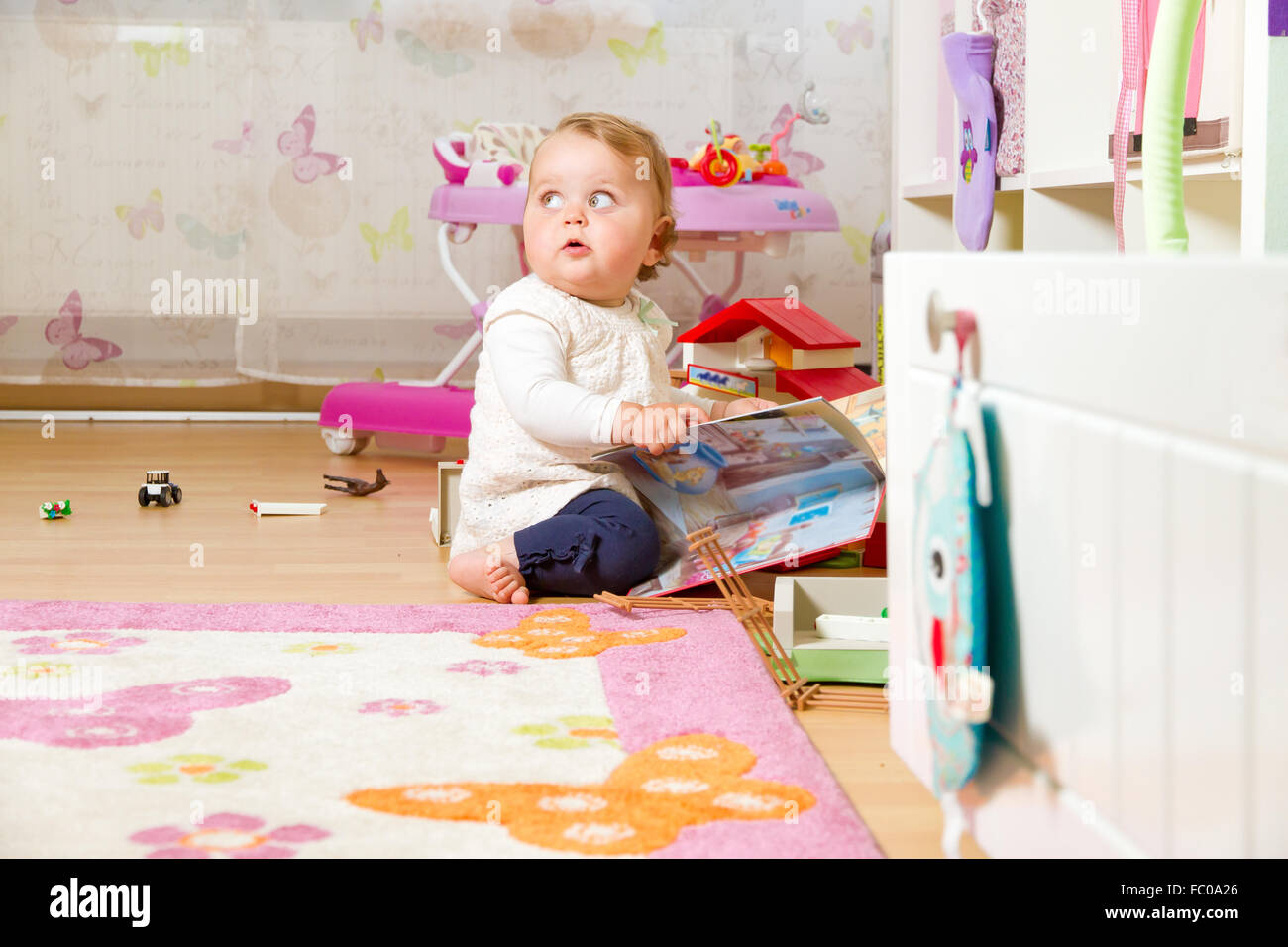 Bébé avec photo livre à la maison Banque D'Images