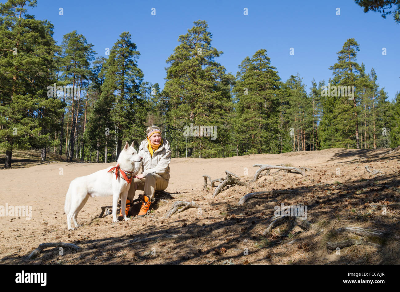 Femme avec un chien blanc dans un bois Banque D'Images