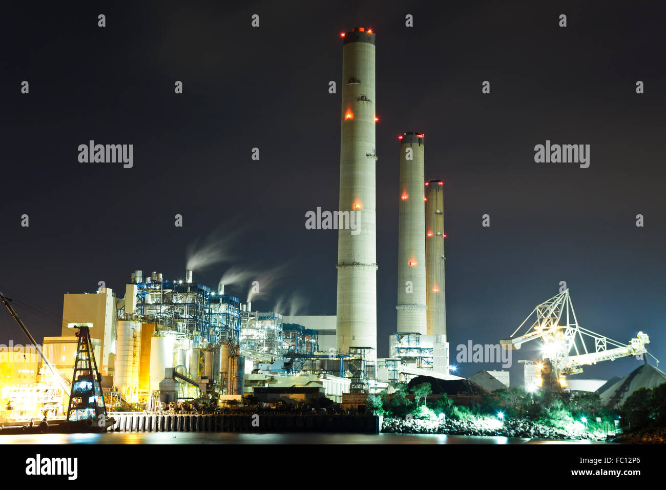 Fumer nuit à l'usine d'alimentation industrielle Banque D'Images