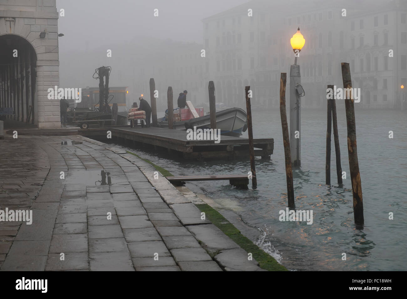Décharger les travailleurs des marchandises d'un bateau amarré sur le Grand Canal à Venise Banque D'Images