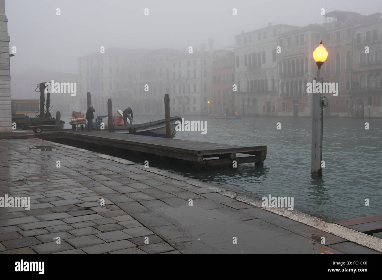 Décharger les travailleurs des marchandises d'un bateau amarré sur le Grand Canal à Venise Banque D'Images