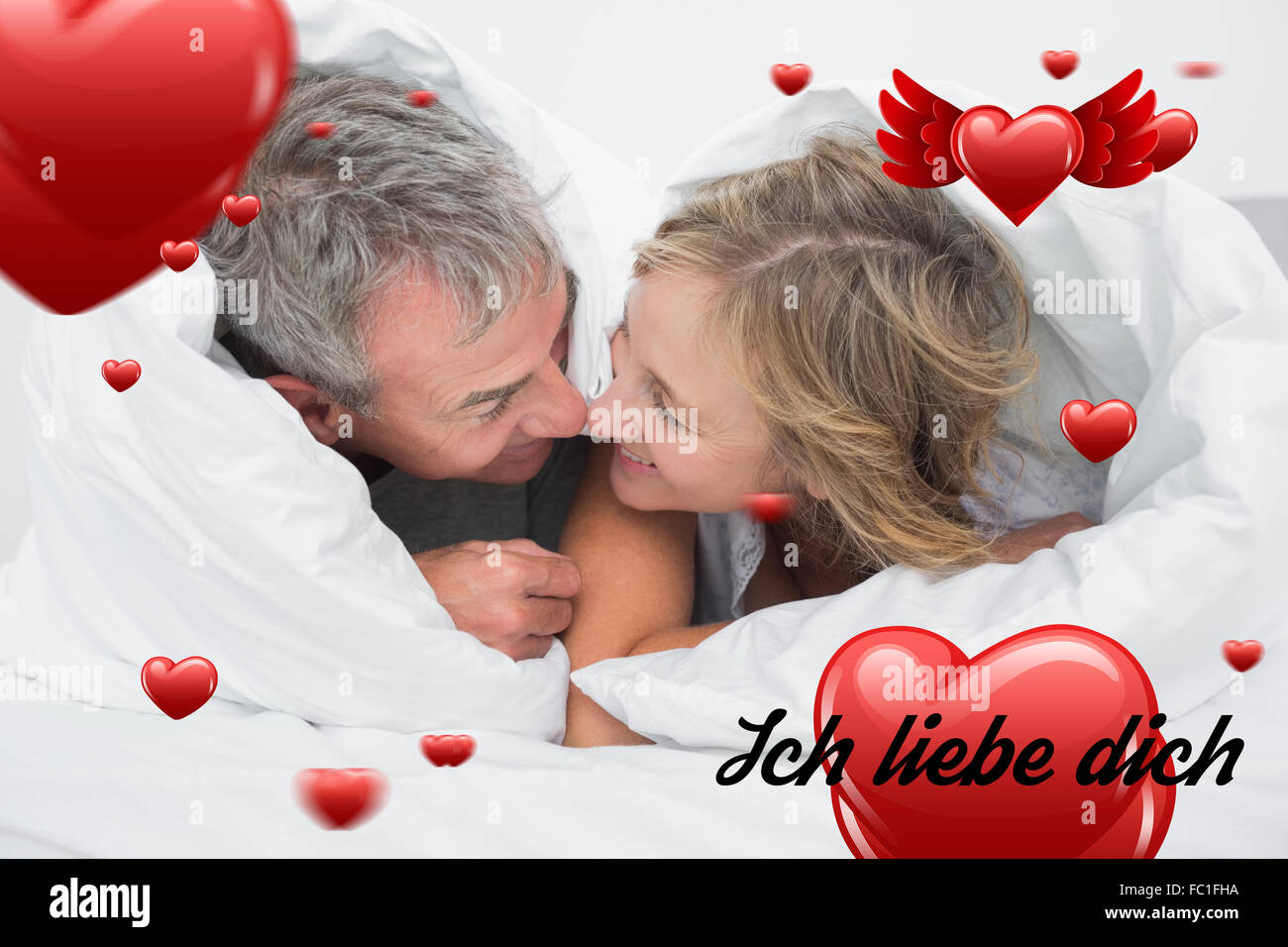 Image composite de l'amour couple d'âge moyen sous la couette Banque D'Images