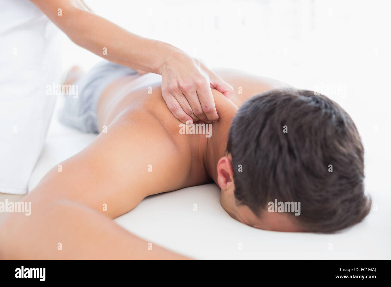 Physiothérapeute massage épaule faisant de son patient Banque D'Images