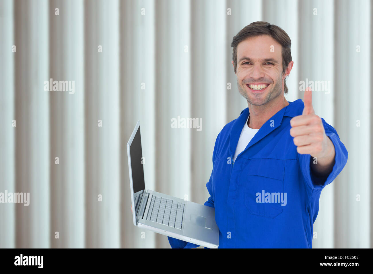 Image composite de mechanic holding laptop while showing Thumbs up Banque D'Images