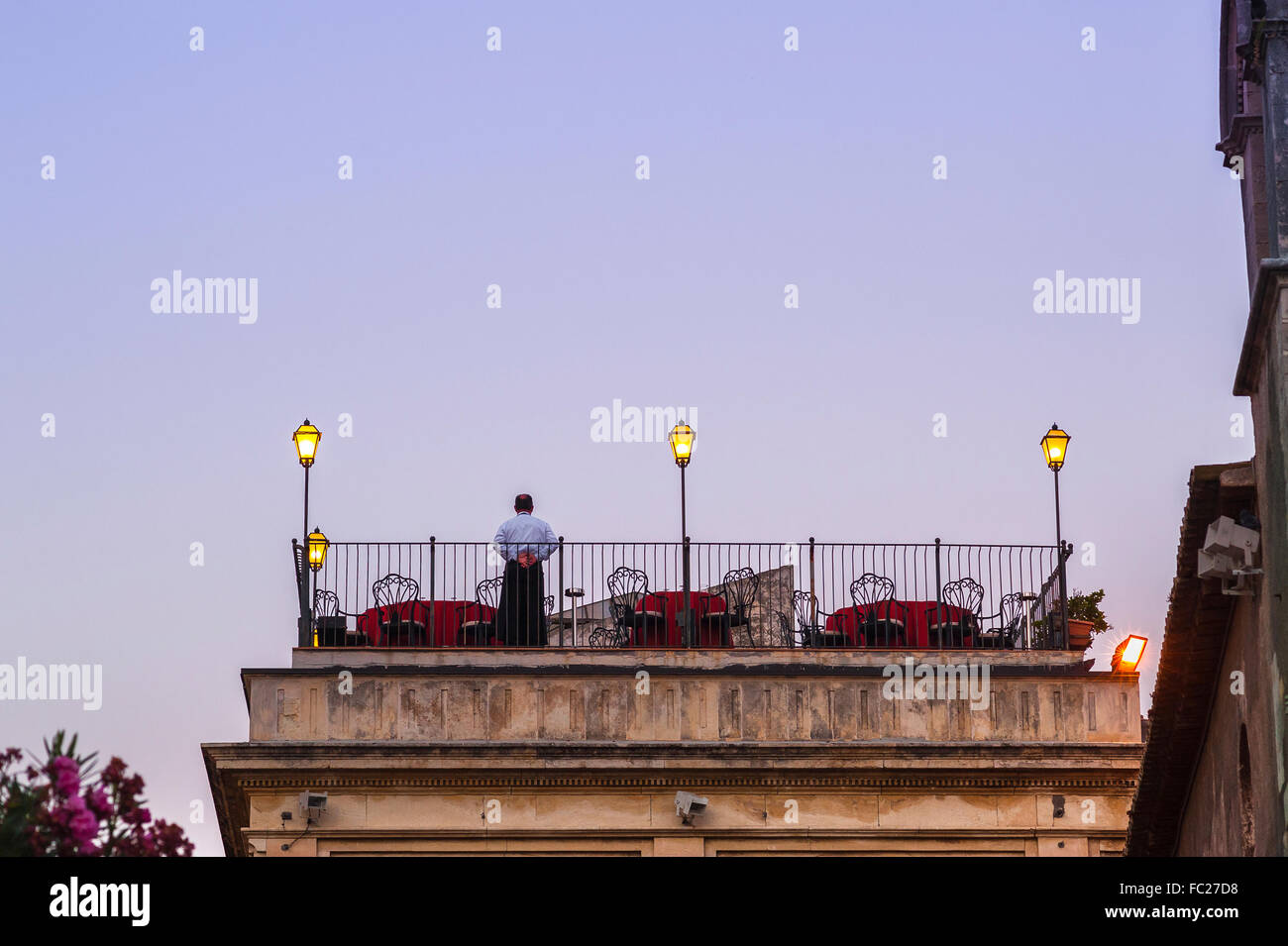 Restaurant terrasse sur le toit, un seul serveur est prêt pour soirée diners pour arriver à une terrasse sur le toit d'un restaurant à Taormina, Sicile. Banque D'Images