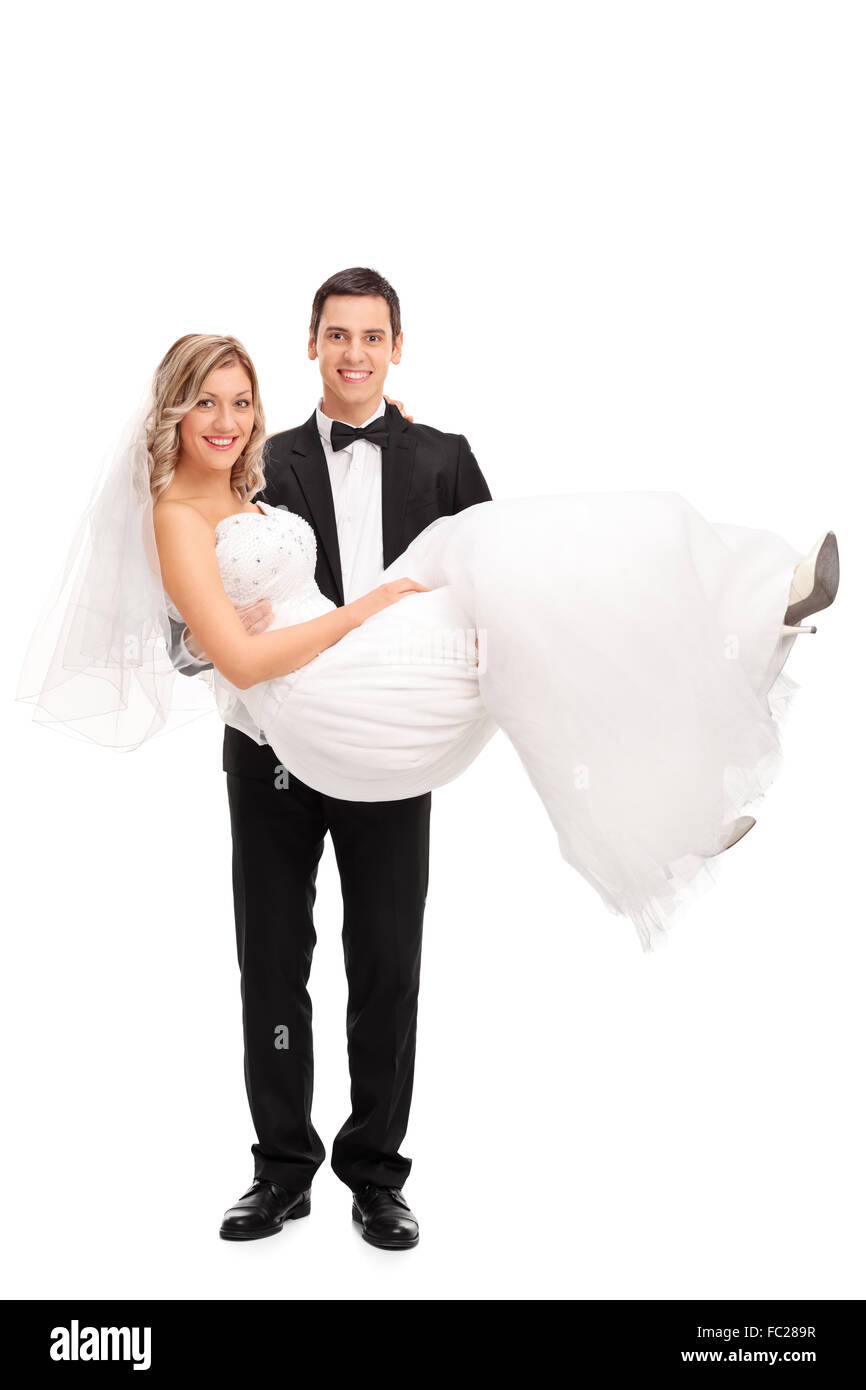 Portrait d'un jeune marié portant la mariée dans ses mains isolé sur fond blanc Banque D'Images
