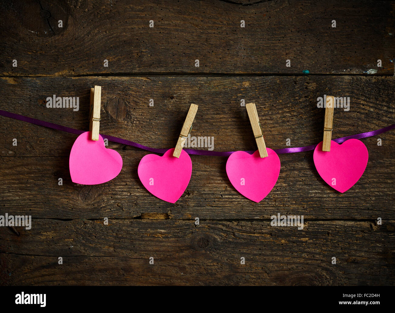 Coeur rose papier coupé avec pinces à linge. Image de saison Jour de Valentines Banque D'Images
