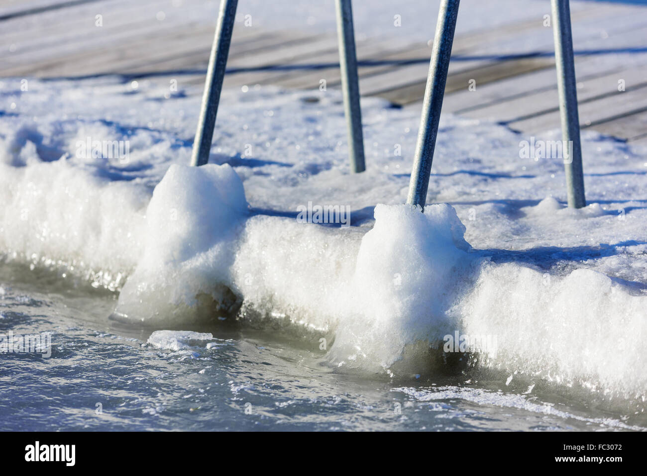 Une piscine ou baignade dock pier a gelé dans la glace de mer à l'hiver. Vu de la mer avec la terre en arrière-plan. H Banque D'Images