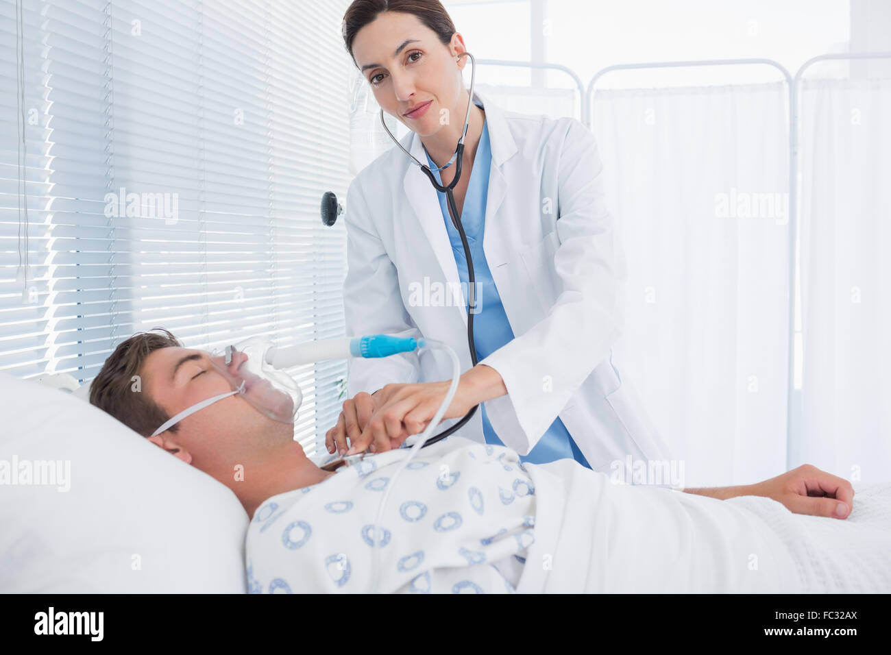 Smiling doctor auscultating ses patients poitrine Banque D'Images