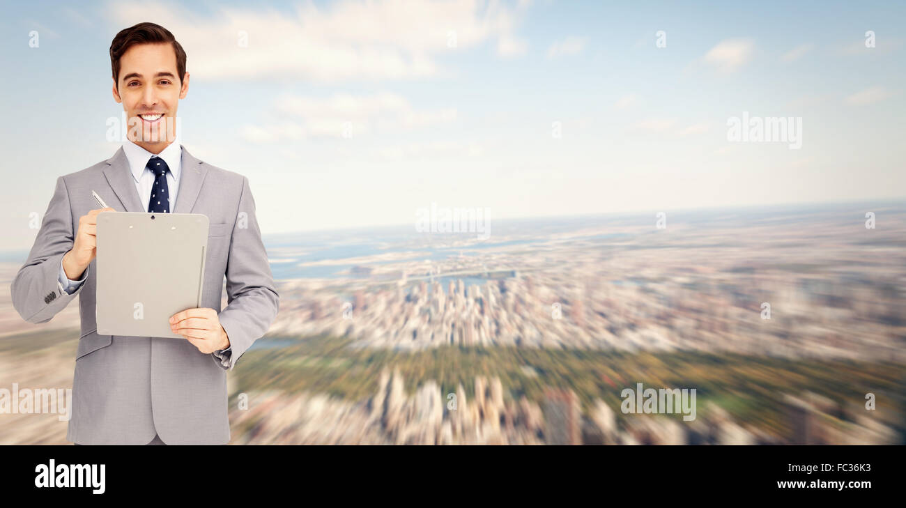 Composite image of businessman holding a clipboard Banque D'Images